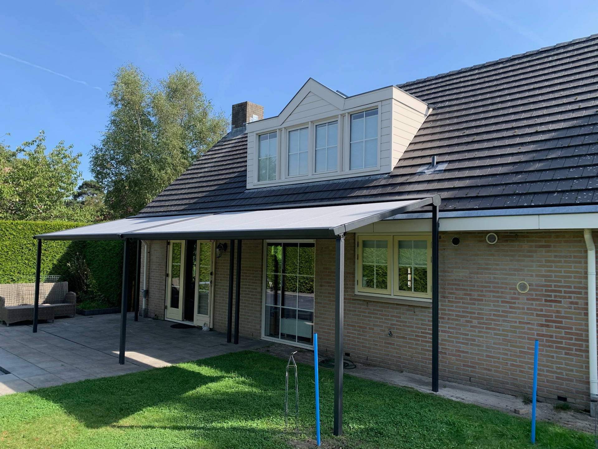 Maatwerk pergola met champagne doek op een Hollandse villa